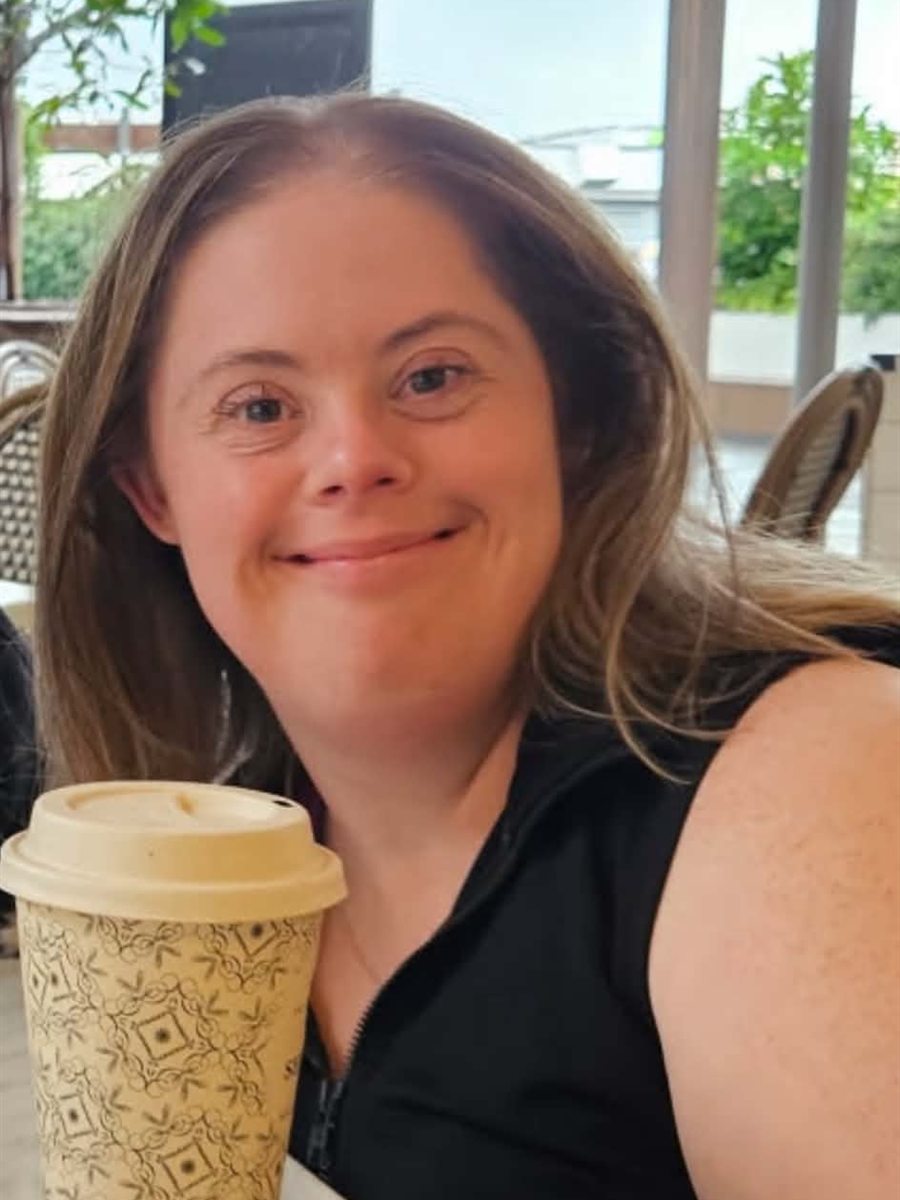Allie out for a coffee, smiling at the camera