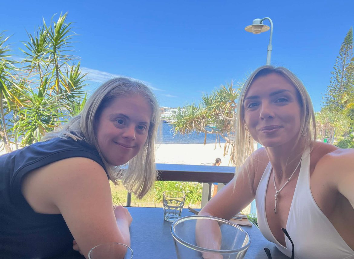 Two people having lunch at a table looking out over the water