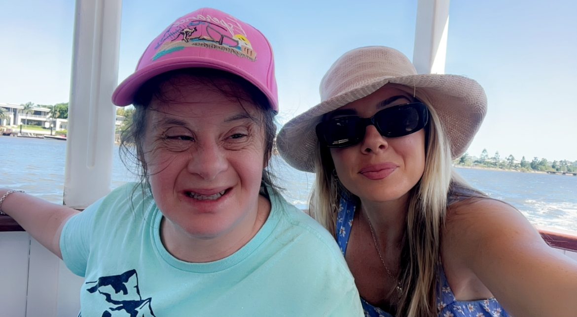 Two people on a boat wearing hats on a sunny day