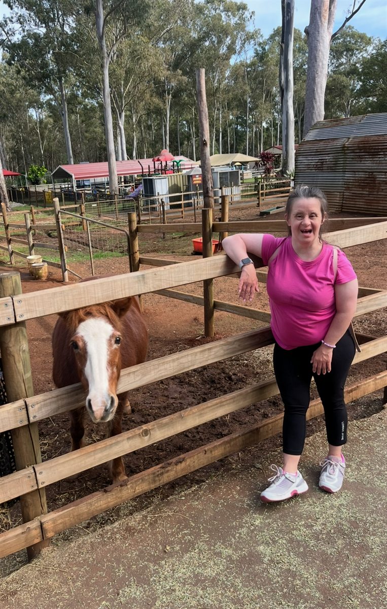 Standing at a fence beside a horse at a farm