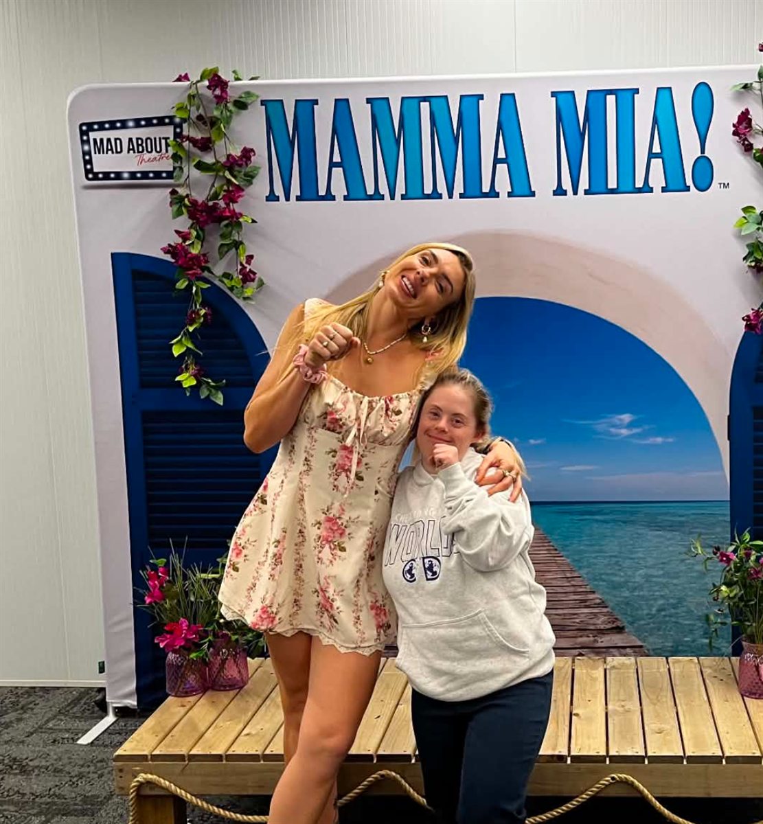 Two people posing at a Mamma Mia photo backdrop